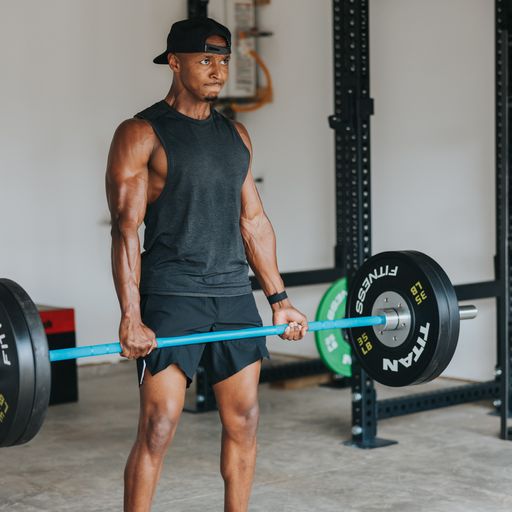 A man at the top of a deadlift rep, looking intense.