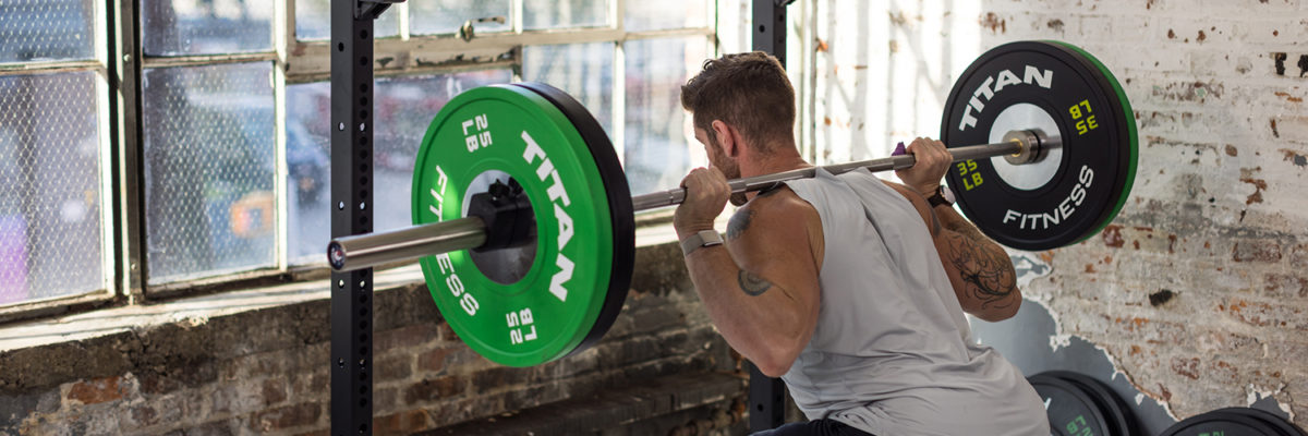 Male squatting with a barbell and weights