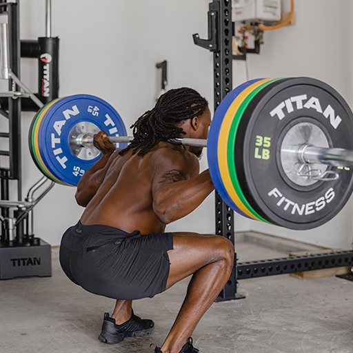 Male performing an exercise with a barbell and weight plates