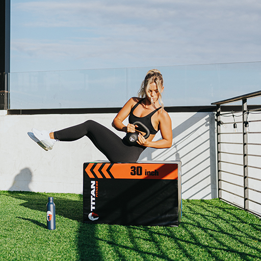 Female using a kettlebell and plyo box