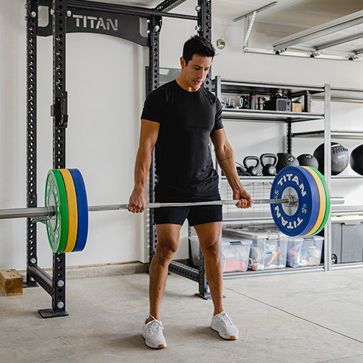 Male holding a barbell with weight plates on either end. 