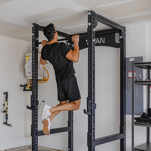 Male doing pull ups in a power rack