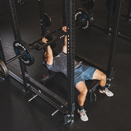 Male doing a bench press in a power rack